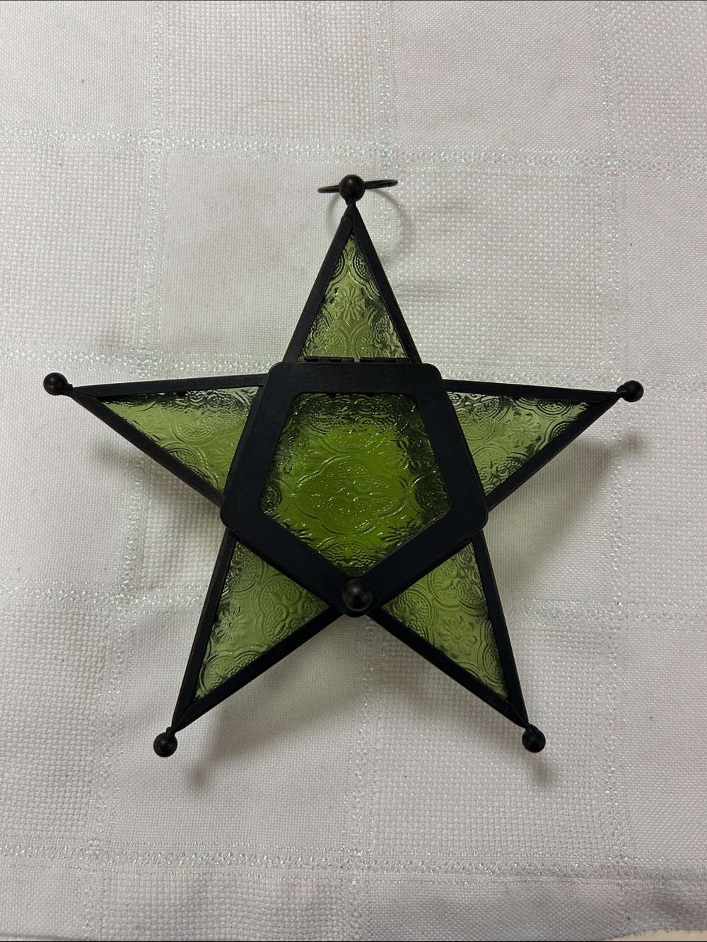 green embossed glass Moroccan-style star lantern for a votive candle.